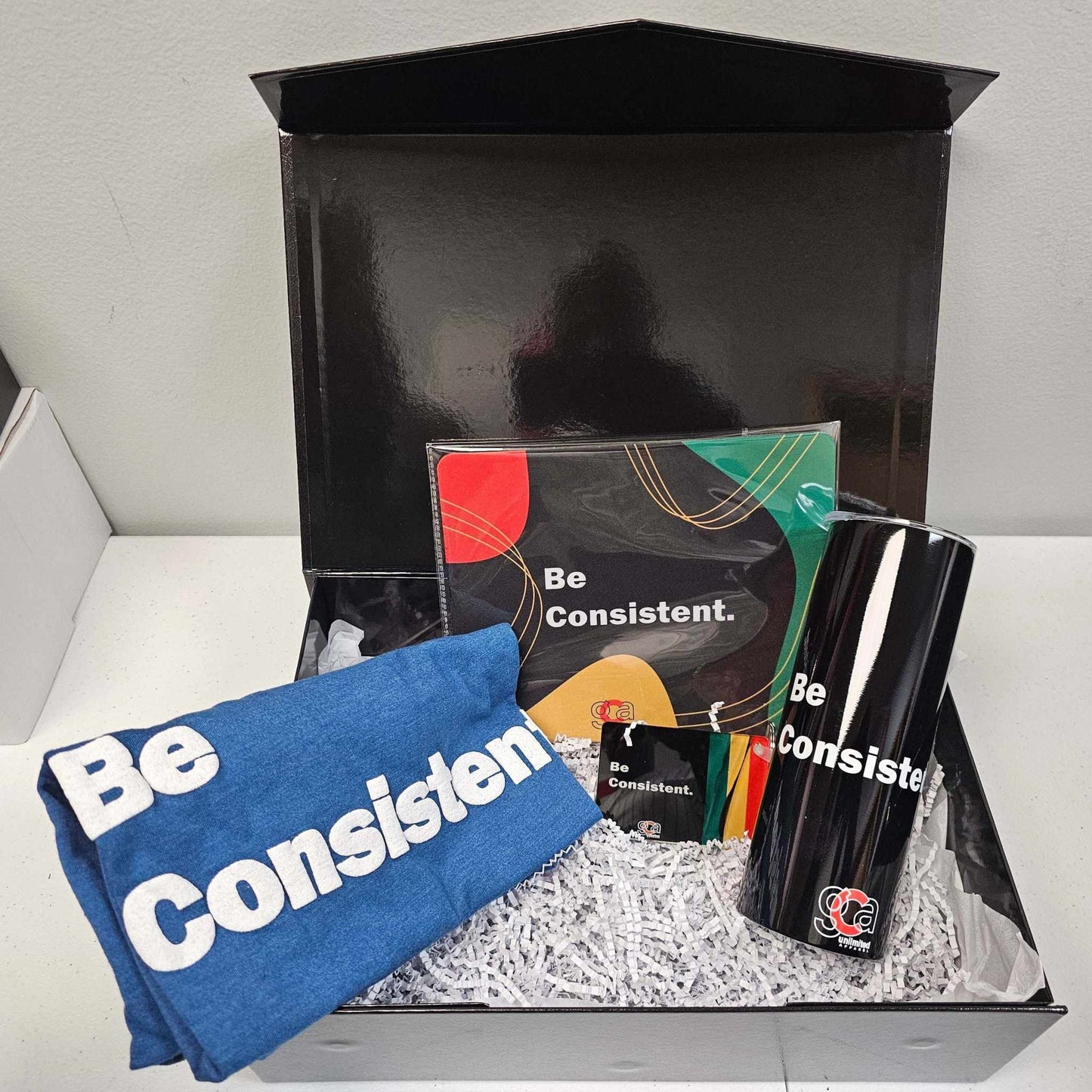 GCA Unlimited Apparel college gift box with hoodie, tumbler, mouse pad, and keychain for students